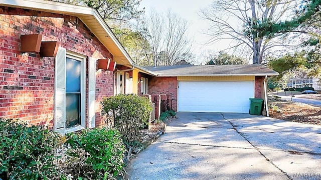 view of home's exterior featuring brick siding, driveway, and an attached garage