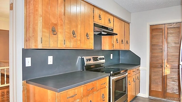 kitchen with electric range, dark countertops, dark wood-style floors, a textured ceiling, and under cabinet range hood