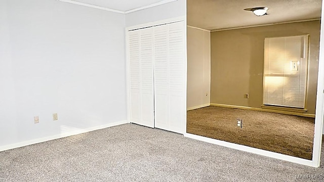 unfurnished bedroom with ornamental molding, carpet, a closet, and baseboards