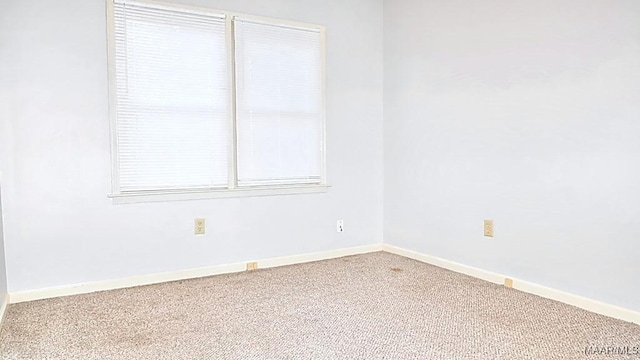 carpeted spare room with baseboards