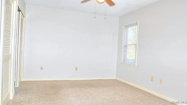 unfurnished room featuring light carpet, a ceiling fan, and baseboards