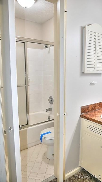 full bathroom featuring toilet, combined bath / shower with glass door, a textured ceiling, and vanity