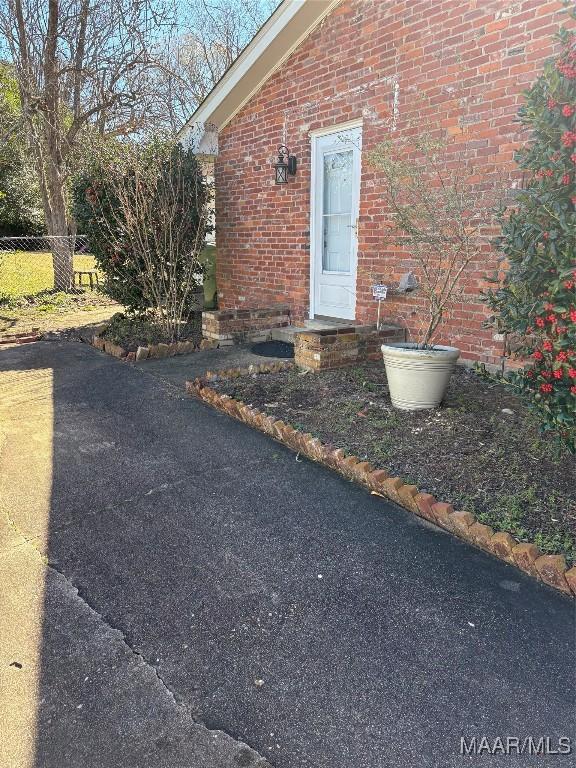 view of exterior entry featuring brick siding