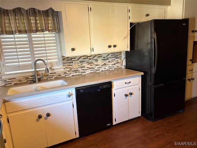 kitchen with tasteful backsplash, dark wood-style floors, light countertops, black appliances, and a sink