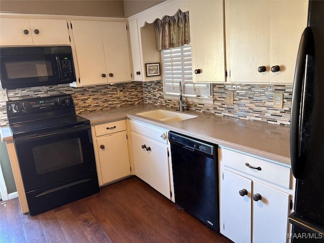 kitchen with black appliances, dark wood-style floors, light countertops, and a sink