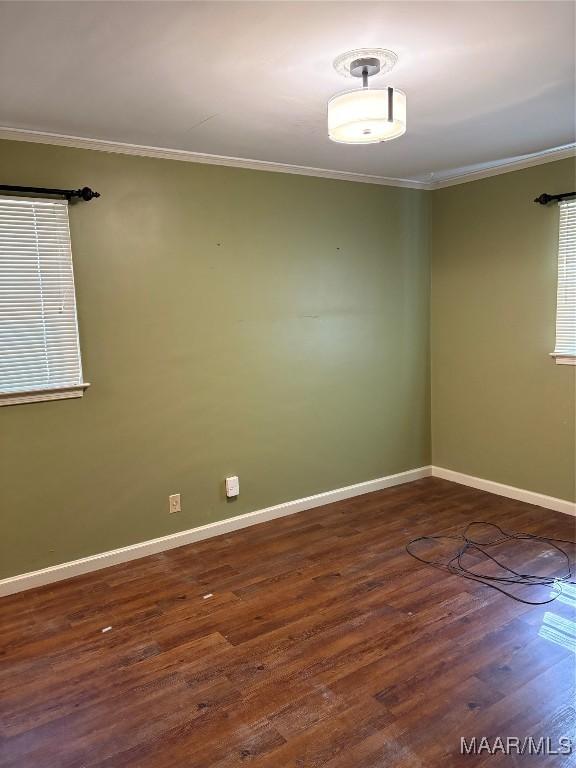 unfurnished room featuring baseboards, ornamental molding, and wood finished floors