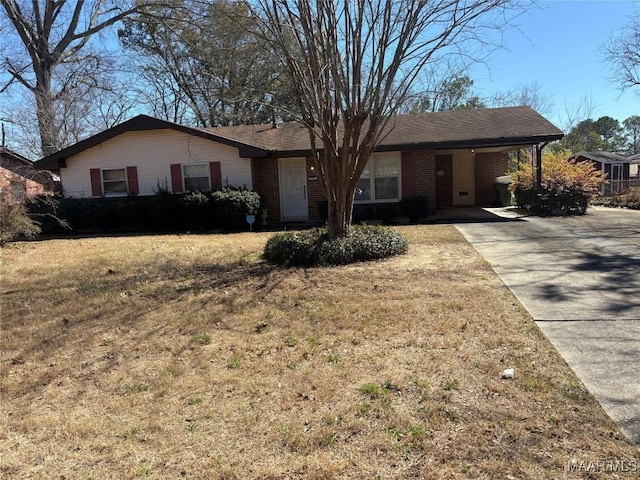 ranch-style home featuring driveway, brick siding, and a front lawn