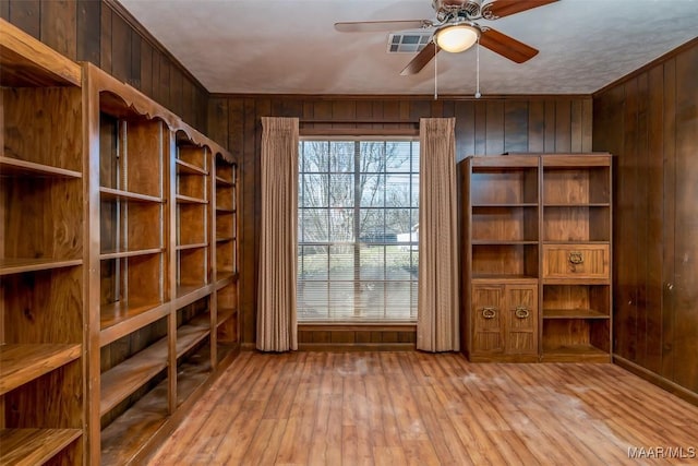 interior space featuring visible vents, wooden walls, and hardwood / wood-style floors