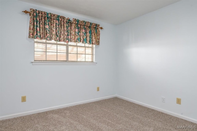 spare room featuring carpet floors and baseboards