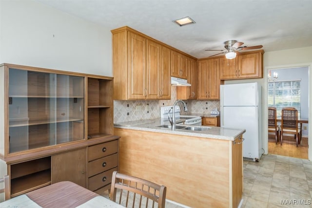 kitchen with light countertops, a sink, ceiling fan, white appliances, and under cabinet range hood