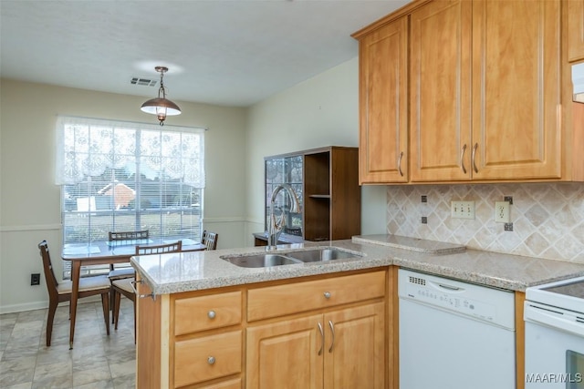 kitchen featuring backsplash, a sink, light stone countertops, white appliances, and a peninsula