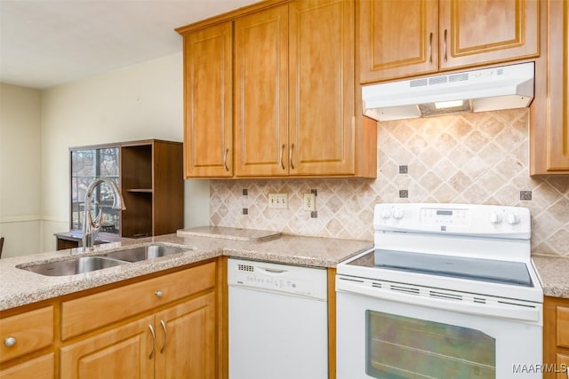 kitchen with light stone counters, backsplash, a sink, white appliances, and under cabinet range hood