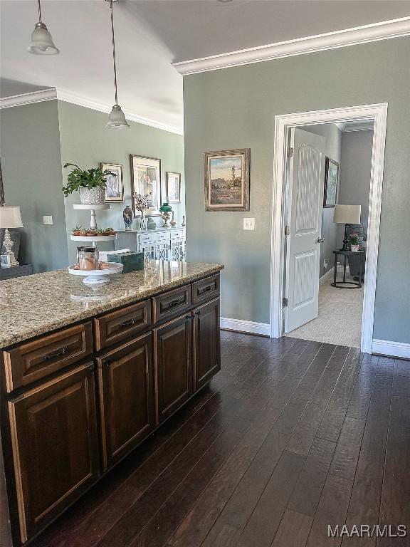 kitchen featuring baseboards, hanging light fixtures, dark wood-style flooring, and crown molding