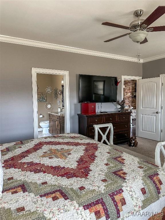 carpeted bedroom with ensuite bath, a ceiling fan, and crown molding