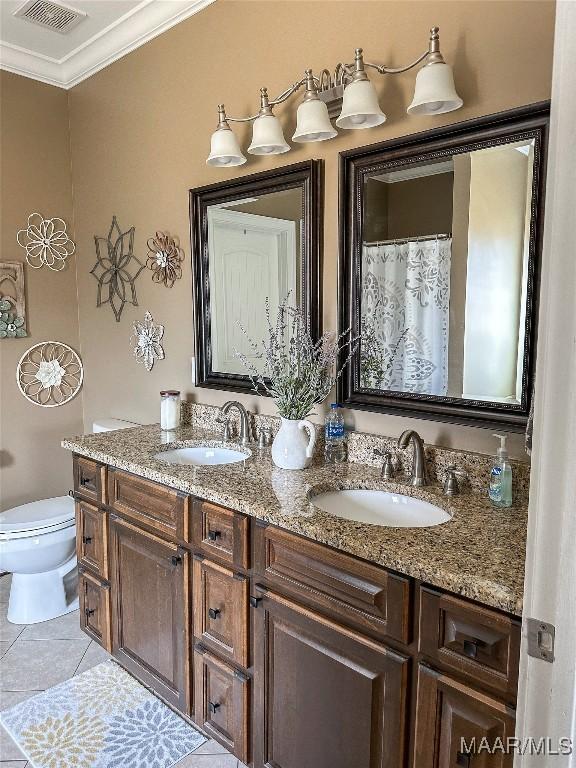 full bath with toilet, ornamental molding, a sink, and visible vents