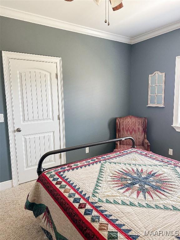 bedroom featuring ornamental molding, carpet, and baseboards