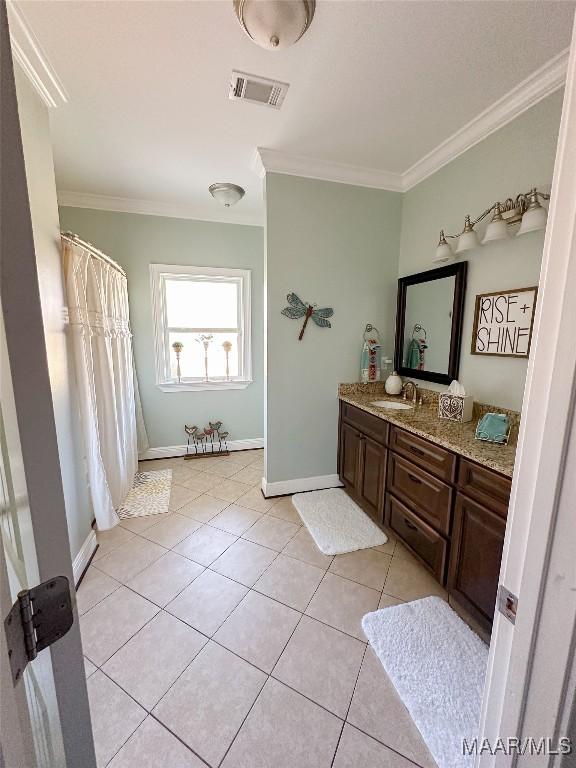 bathroom with tile patterned flooring, vanity, visible vents, baseboards, and ornamental molding