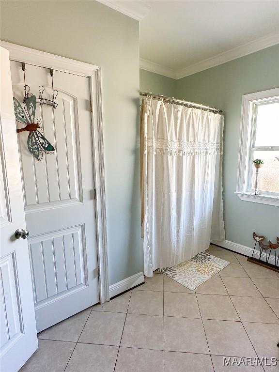 bathroom featuring ornamental molding, a shower with curtain, baseboards, and tile patterned floors