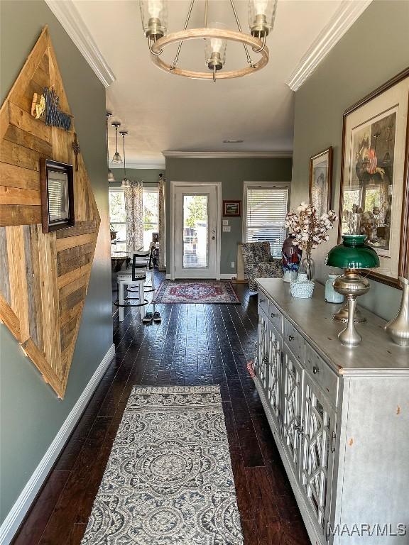 entryway with baseboards, ornamental molding, hardwood / wood-style flooring, and an inviting chandelier