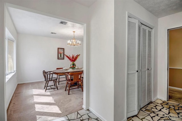 corridor featuring a chandelier, visible vents, light carpet, and baseboards