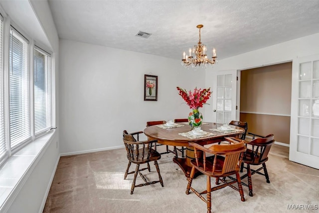 dining room with light carpet, baseboards, visible vents, a textured ceiling, and a notable chandelier