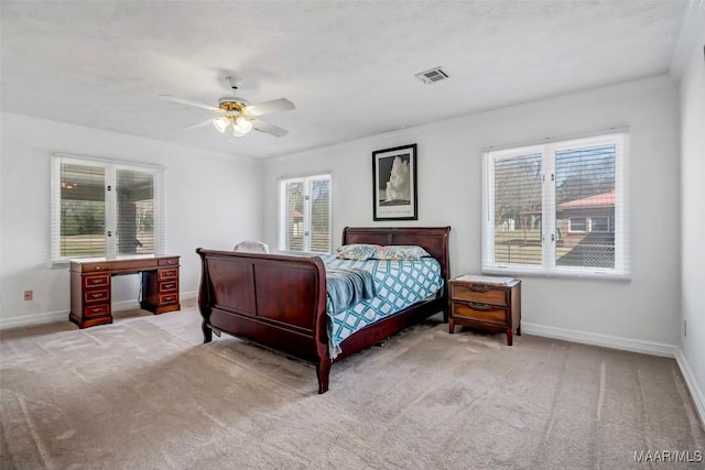 carpeted bedroom featuring a ceiling fan, visible vents, and baseboards