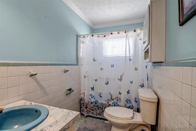 full bath with tile walls, a sink, a textured ceiling, and toilet