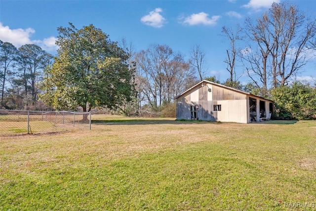 view of yard with an outbuilding, a pole building, and fence