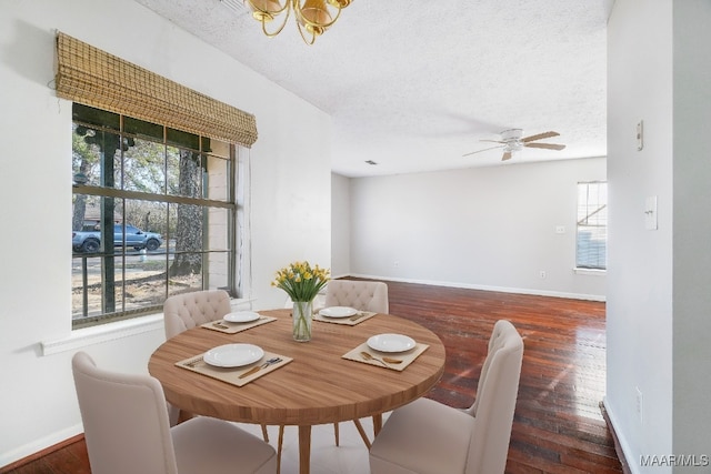 dining space with a textured ceiling, hardwood / wood-style flooring, and baseboards