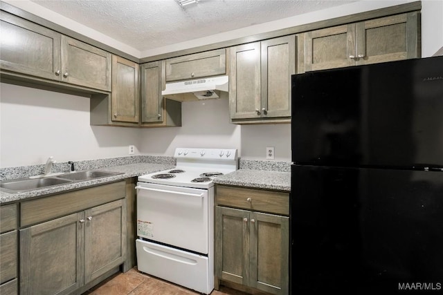 kitchen featuring a textured ceiling, under cabinet range hood, a sink, white range with electric stovetop, and freestanding refrigerator