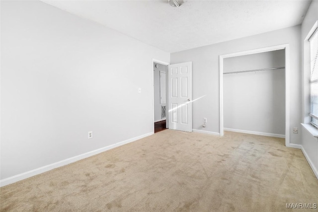 unfurnished bedroom with carpet floors, a closet, and baseboards