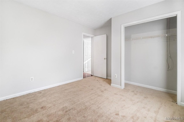 unfurnished bedroom with carpet, baseboards, and a closet