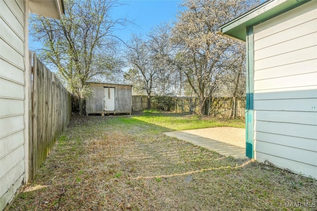 view of yard featuring an outbuilding, a shed, and a fenced backyard