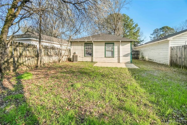 rear view of house with cooling unit, a fenced backyard, a yard, and a patio