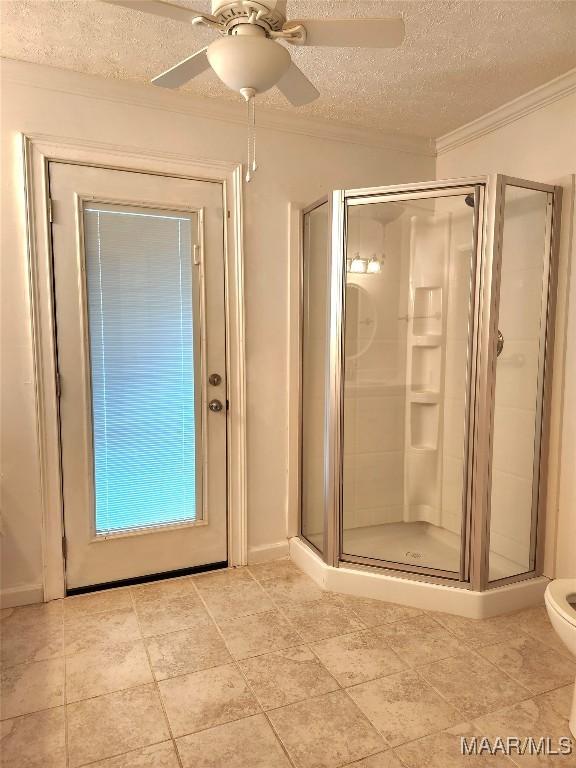 full bath with a stall shower, a textured ceiling, a ceiling fan, and crown molding