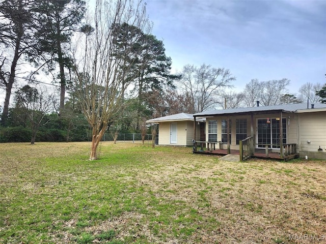 back of property featuring fence, metal roof, and a lawn