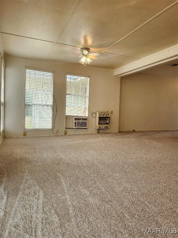 unfurnished living room featuring carpet, cooling unit, a ceiling fan, and heating unit