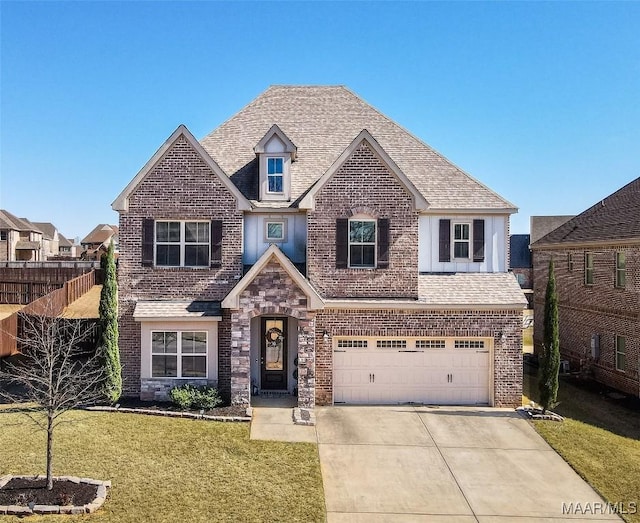 traditional-style home with driveway, a front lawn, a shingled roof, and brick siding