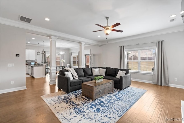 living room featuring visible vents, ornate columns, and wood finished floors