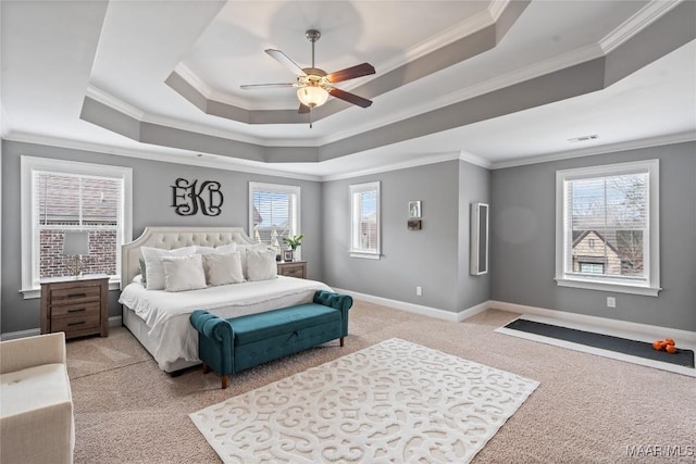 bedroom with a tray ceiling, light colored carpet, crown molding, and baseboards