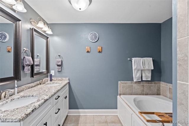 bathroom with double vanity, baseboards, a sink, and tile patterned floors