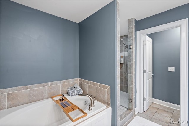 full bath with a stall shower, tile patterned floors, baseboards, and a bath