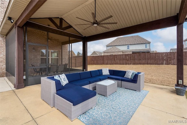 view of patio / terrace featuring a sunroom, outdoor lounge area, a fenced backyard, and a ceiling fan