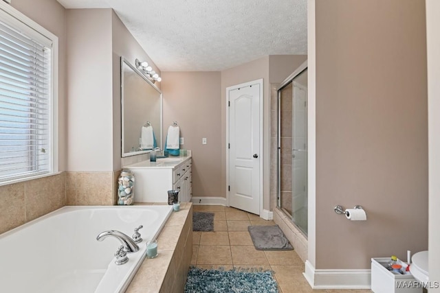 bathroom with a shower stall, vanity, a textured ceiling, and tile patterned floors