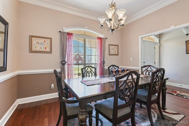 dining space with baseboards, ornamental molding, dark wood finished floors, and a chandelier