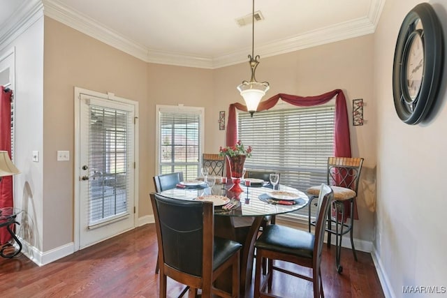 dining area with baseboards, wood finished floors, visible vents, and crown molding