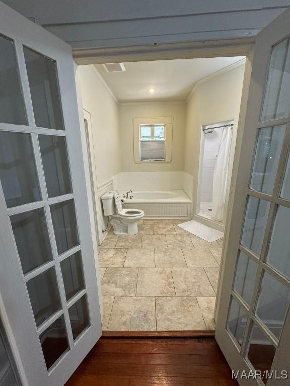 full bathroom with wood finished floors, walk in shower, a garden tub, and crown molding