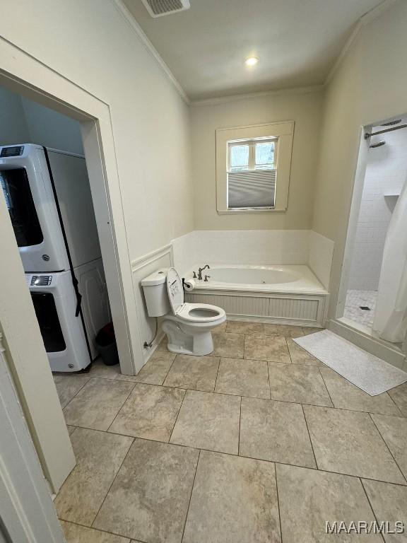 full bathroom featuring tile patterned flooring, a garden tub, toilet, ornamental molding, and a stall shower