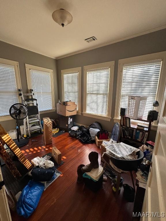 interior space featuring crown molding, visible vents, and wood finished floors