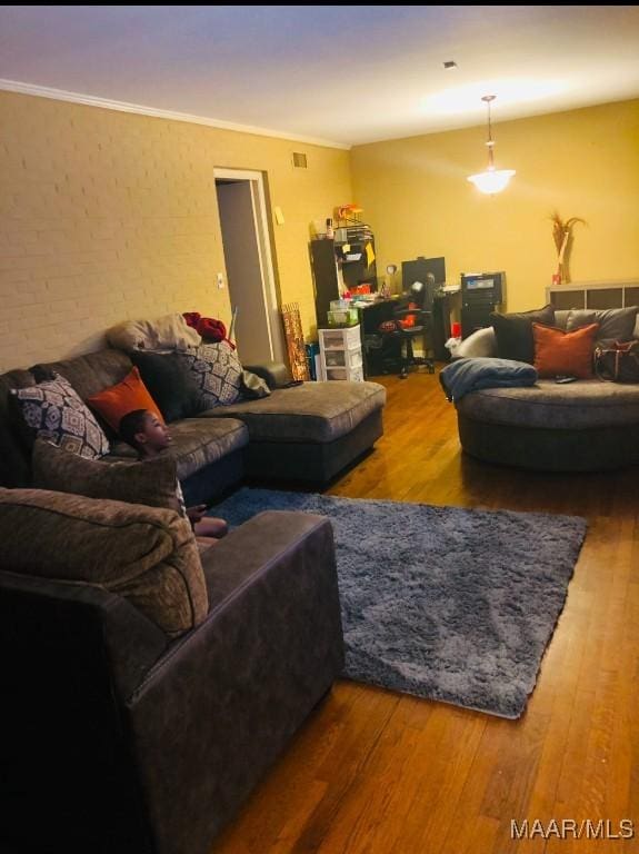 living area with ornamental molding and wood finished floors